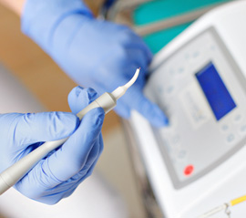 a dentist holding a soft tissue dental laser