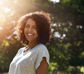 a smiling woman standing outside