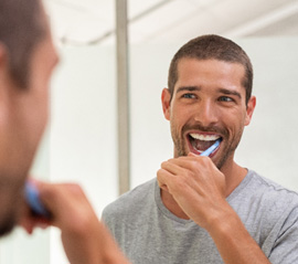 a man brushing his teeth in a bathroom