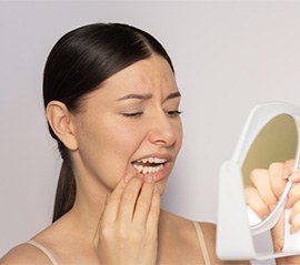 Concerned woman looking at her gums in mirror
