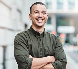 Man in button up shirt smiling outside