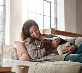 Woman relaxing on couch with her dog