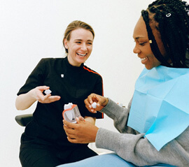dentist showing patient a model of a dental crown