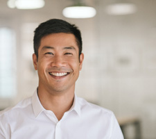 Man in white button up shirt smiling in office