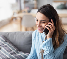 Woman smiling while talking on phone at home
