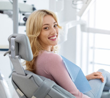 Patient smiling while sitting in treatment chair