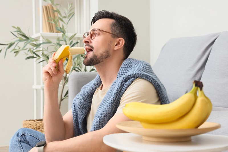 a man relaxing at home and eating a banana